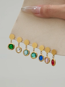 Detail of seven pairs of round faceted glass stone earrings in vibrant diverse colors