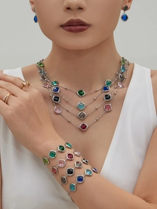 Close-up of multilayer silver necklace and matching bracelets with colorful faceted stones