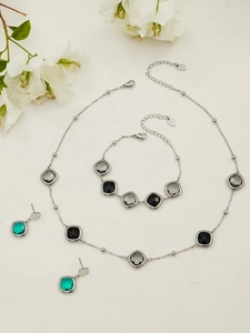 Macro detail of geometric faceted glass stone jewelry set with stainless steel finish