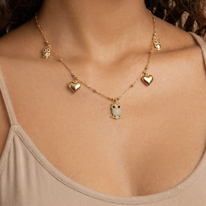 Halskette mit Eulen- und Herzanhänger aus Gold mit Zirkon auf einem Modell