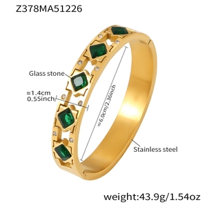 Detailed view of gold stainless steel hinge bracelet with green emerald glass and zircons