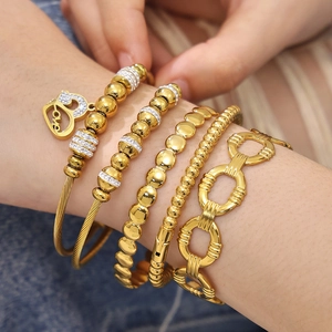 Set of 5 gold stainless steel bracelets featuring heart charm and zircon bead layering