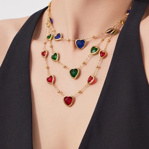Collier doré à trois couches avec pierres en verre colorées en forme de cœur sur mannequin