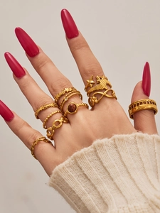 Detail of 10-piece gold plated rings set featuring star and infinity designs on fingers
