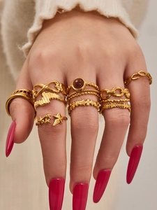 Macro detail of bohemian 18K gold plated ring set with red gemstone and stackable bands