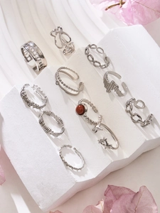 Silver retro ring set with star, heart, and brown stone details on marble display