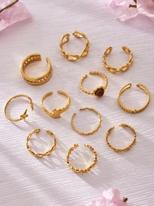 Detailed view of a 10-piece 18K gold plated vintage ring set on a wooden surface with petals