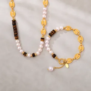 Detailopname van koffieboon ketting en armband set met witte parels en gouden accenten