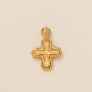 Detailed macro view of 18K gold plated cross pendant with frosted texture and beaded edge