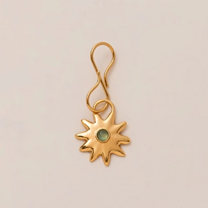 Detail eines Vintage Goldanhängers mit Sonnenstrahlen, grünem Edelstein und S-Hakenverschluss