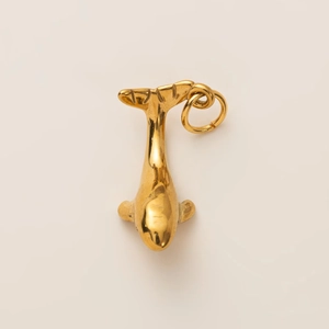 Détail d'un pendentif dauphin plaqué or 18K avec une finition métallique polie