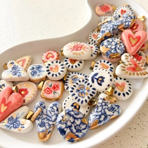 Détail de pendentifs floraux en céramique plaqués or 18 carats sur un plateau