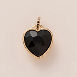 Detail of heart-shaped black faceted gemstone pendant with gold frame and crystal bail