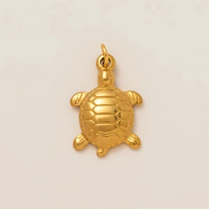 Détail macro du pendentif tortue de mer plaqué or 18K avec une carapace texturée