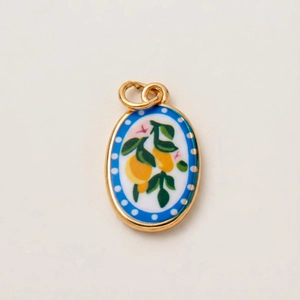 Detail of gold-plated oval pendant with colorful enamel lemon and flower pattern