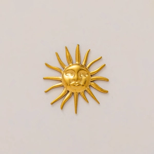 Detalle del colgante de sol en acero chapado en oro 18K con un tallado artístico en relieve