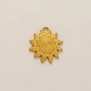 Detalle de un colgante de sol chapado en oro de 18K con textura espiral y grabados en relieve
