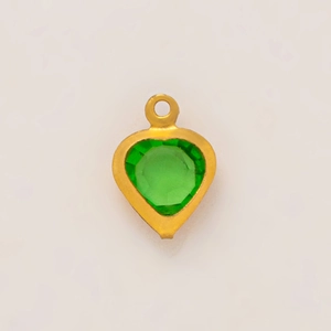 Detalle del colgante de corazón chapado en oro de 18K con una gema facetada verde