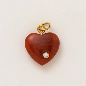 Detail of a heart-shaped red agate pendant with a small diamond and gold plated loop