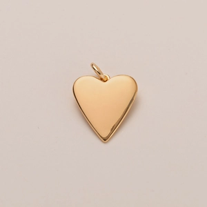 Vista detallada de un colgante de corazón bañado en oro de 14K con acabado espejo brillante