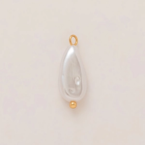 Detailed view of teardrop pearl pendant with 18K gold plated loop on beige texture