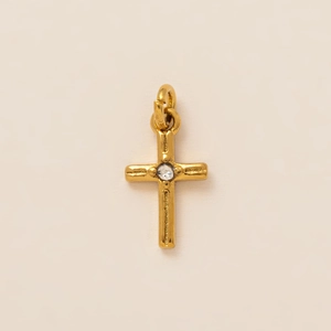 Macro detail of 18K gold-plated stainless steel cross pendant with central zircon stone