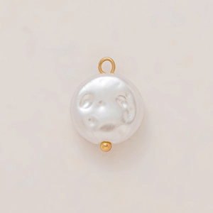 Macro detail of Baroque pearl pendant with 18K gold plated ring and natural texture