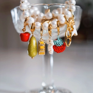 Collier de perles coloré avec pendentifs fruits comme pomme et fraise sur un verre