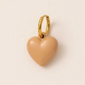 Detailed view of gold plated heart pendant with glossy beige enamel finish on cream background