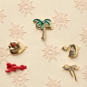 Detail of DIY flip-flop charms featuring coconut tree, swan, and lobster in gold finish