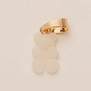Detailed macro view of a 14K gold-plated clasp and white sugar-textured teddy bear charm