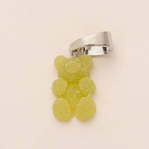 Detailopname van een groene gummibeer hanger met matte textuur en zilveren metalen sluiting