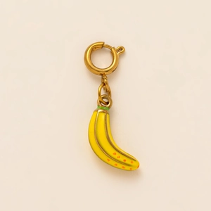 Dettaglio macro di un ciondolo a forma di banana in smalto giallo con chiusura dorata