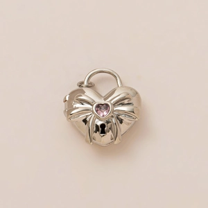 Detailed view of silver heart locket pendant with pink stone and bowknot ornament
