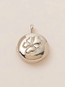 Detailed top view of a silver floral locket with a central sparkling rhinestone