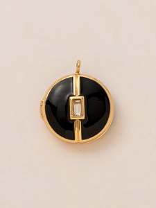 Detailed macro view of a vintage gold locket pendant with black enamel and zircon inlay