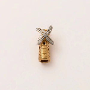 Detailed macro of a 18K gold plated windmill pendant featuring silver hollow blades
