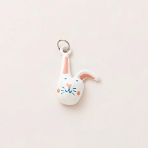 Cute white rabbit pendant with pink ears and blue details on a golden metal ring