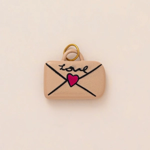 Macro detail of envelope pendant with Love text and glitter heart for DIY jewelry base