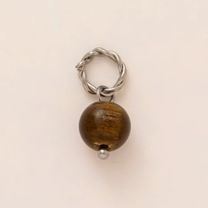 Macro shot of a vintage twisted silver pendant with a textured brown wooden bead accessory