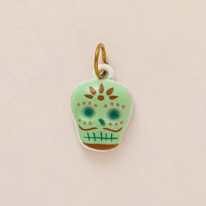 Detail of green sugar skull charm with floral engraving and 18k gold plated ring