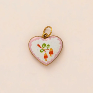 Detail of heart-shaped gold-plated pendant with vintage botanical pattern and top loop
