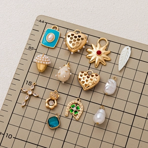 Chic gold-plated charms including hearts, stars, and pearls on a scale measurement board