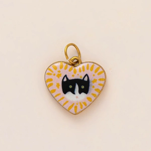 Detail of a 18k gold-plated heart pendant featuring a cute black and white cat motif