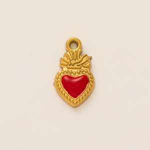 Macro view of vintage 18K gold plated heart pendant with red enamel and sunburst detail