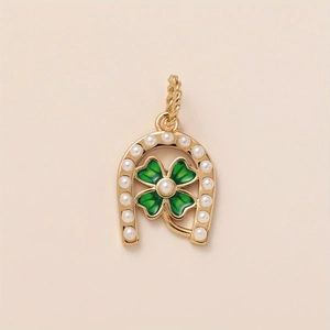 Detailed macro view of gold horseshoe pendant with green clover and small white pearls