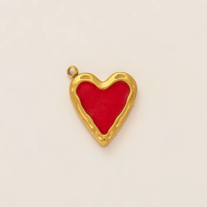 Detailed view of heart-shaped gold-plated pendant with vintage texture and red inlay