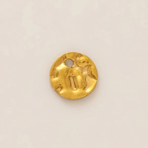 Macro detail of irregular hammered texture on 18K gold-plated round metal DIY pendant