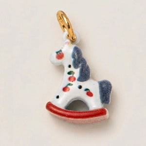 Dettaglio di un ciondolo a cavallo a dondolo in ceramica con motivi di ciliegie