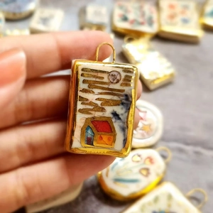 Macro detail of rectangle floral enamel pendant with 18K gold plated frame and bail